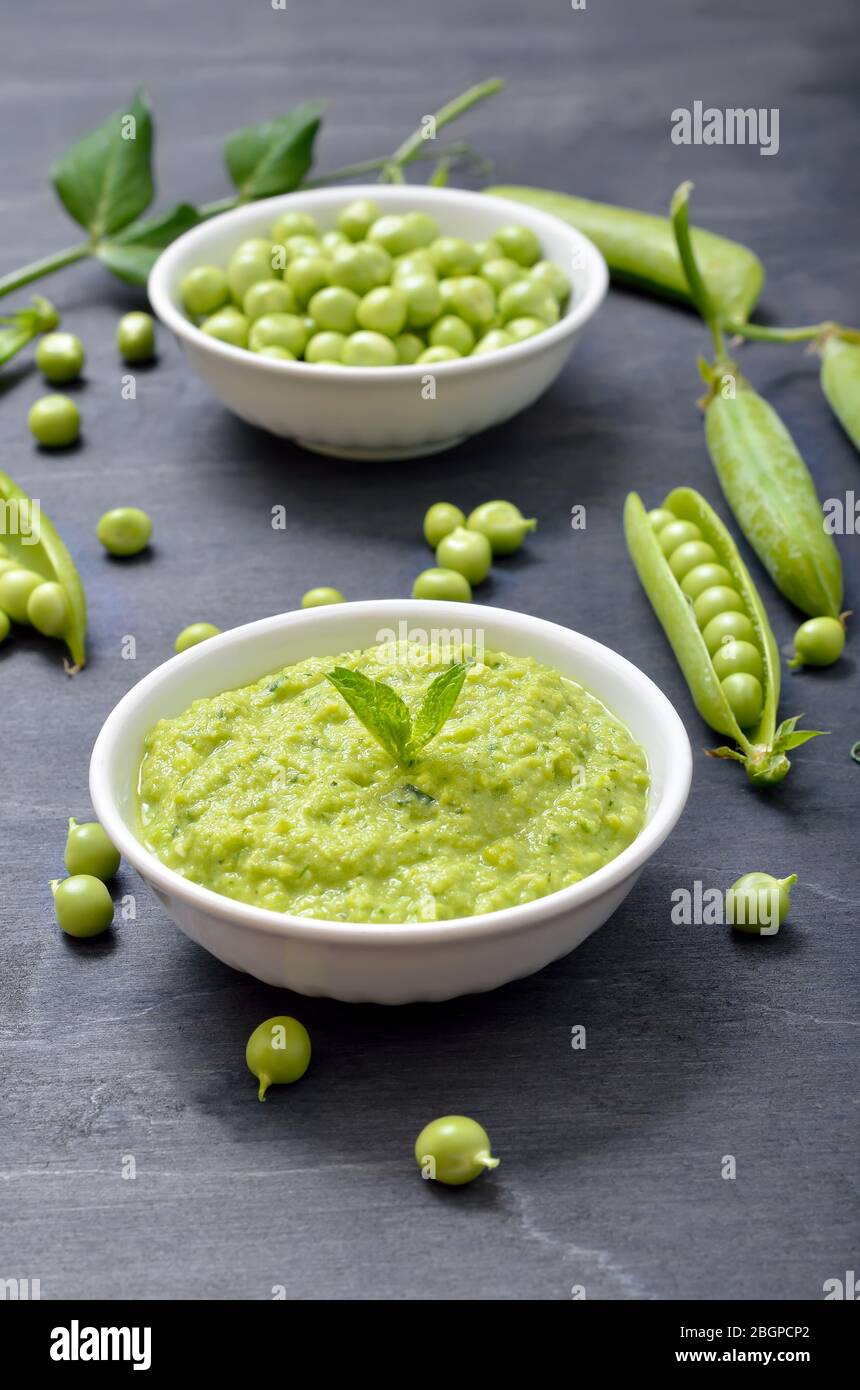 Homemade green pea puree in white bowl. Vegetarian food Stock Photo
