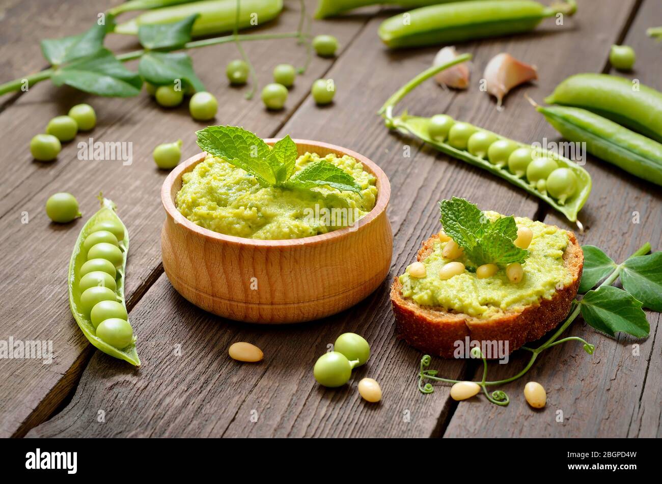 Homemade green pea puree in wooden bowl Stock Photo