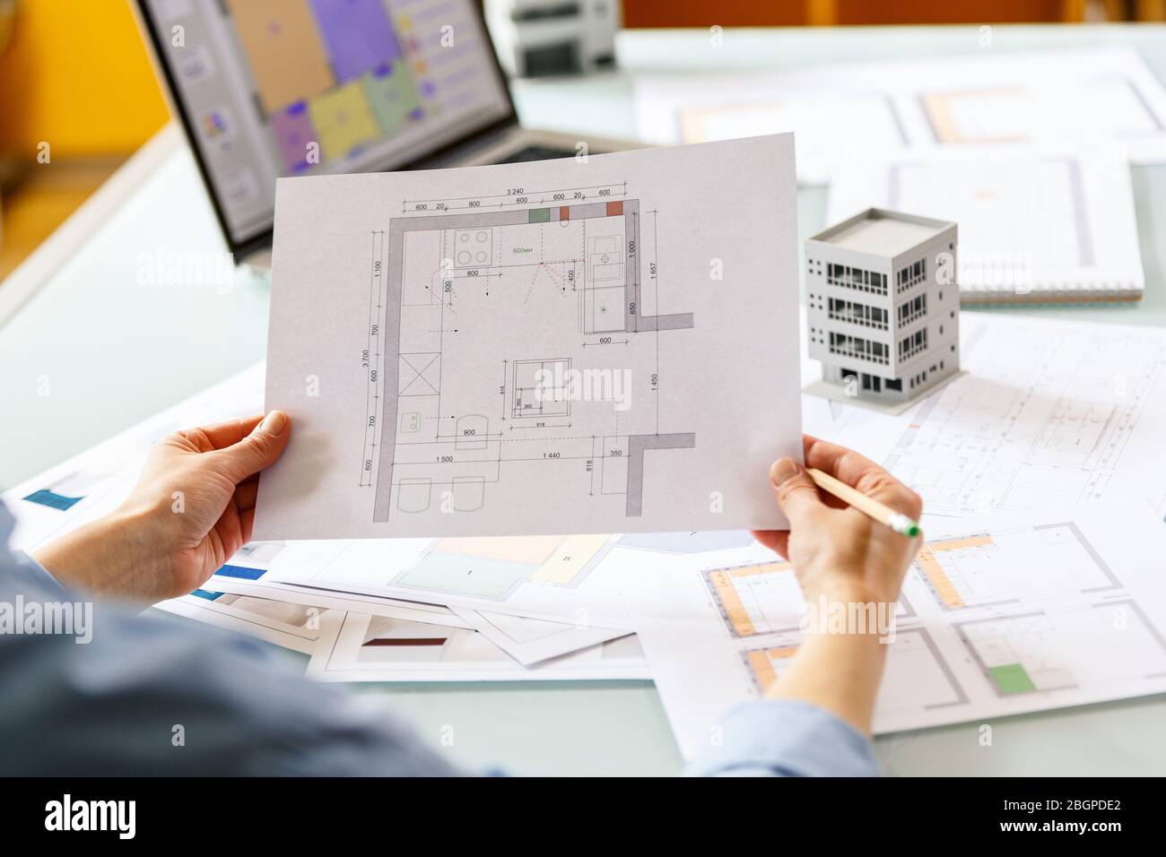 Interior designer working with an apartment plans in a studio, with blueprints and laptop on a table. Architectural desigh bureau working concept Stock Photo