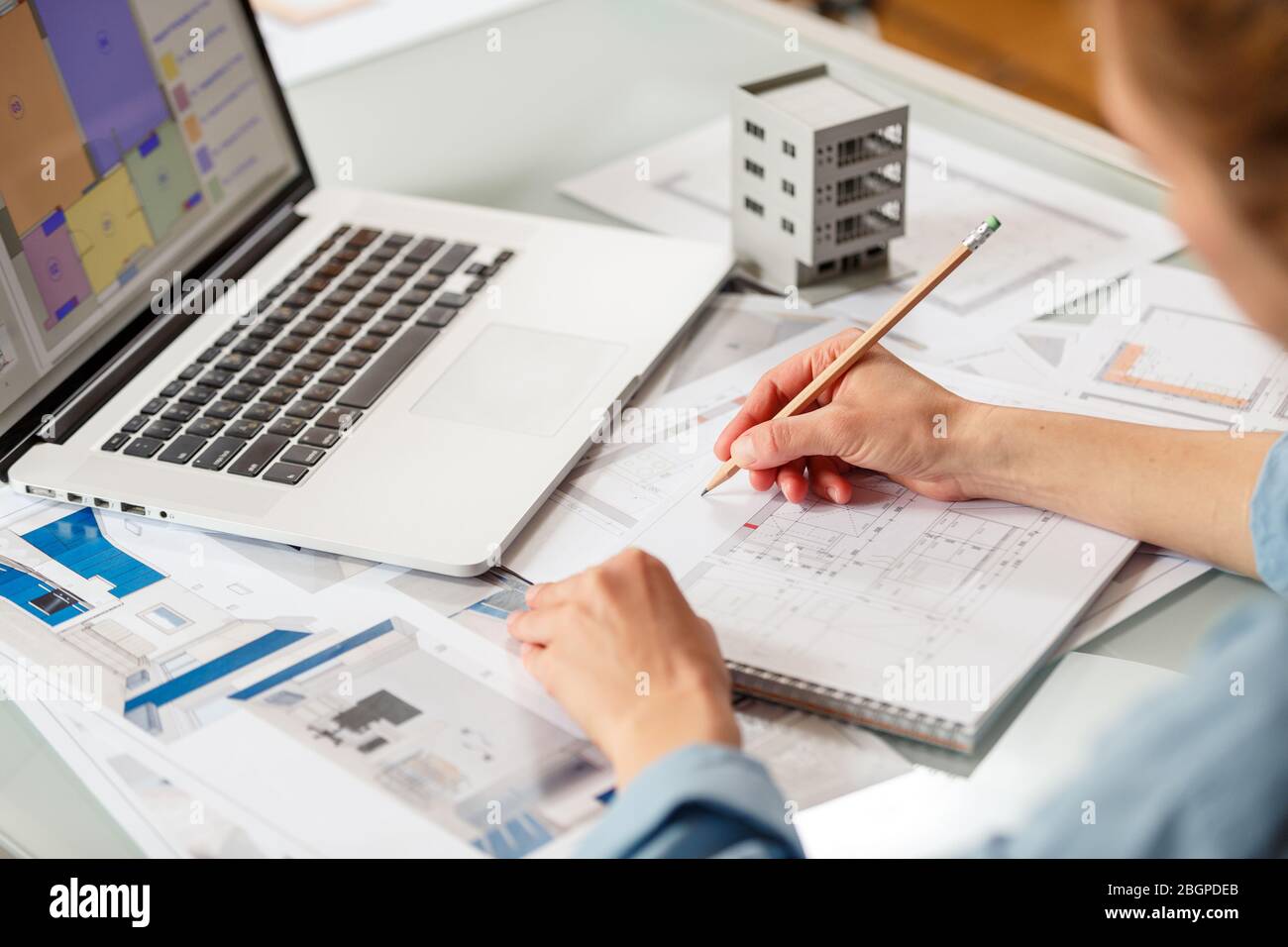 Interior designer working with an apartment plans in a studio, with blueprints and laptop on a table. Architectural desigh bureau working concept Stock Photo