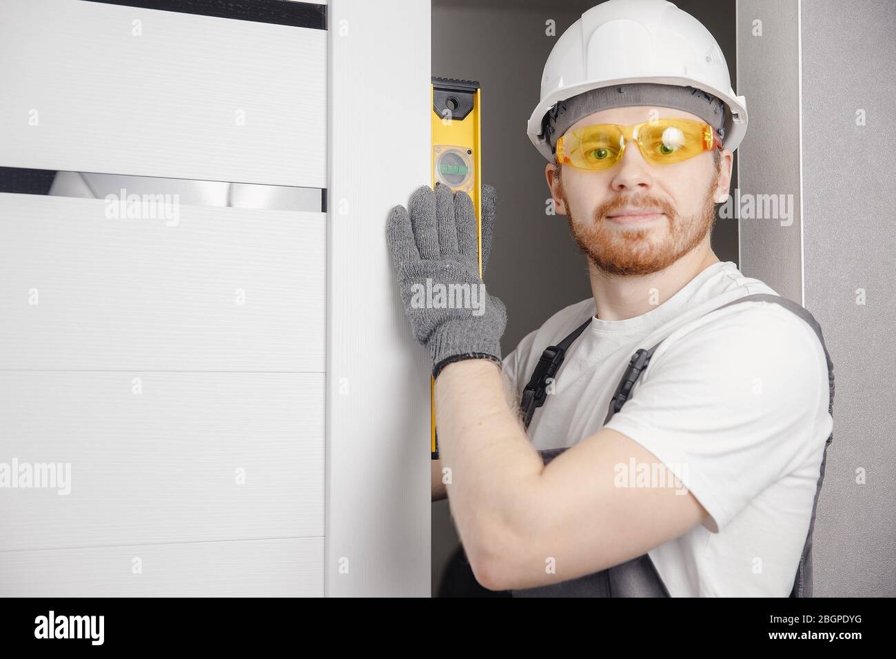 Carpenter worker installation process of wood door hinge tool level Stock Photo