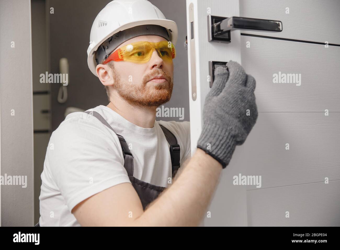 Carpenter worker installation process of wood door hinge Stock Photo