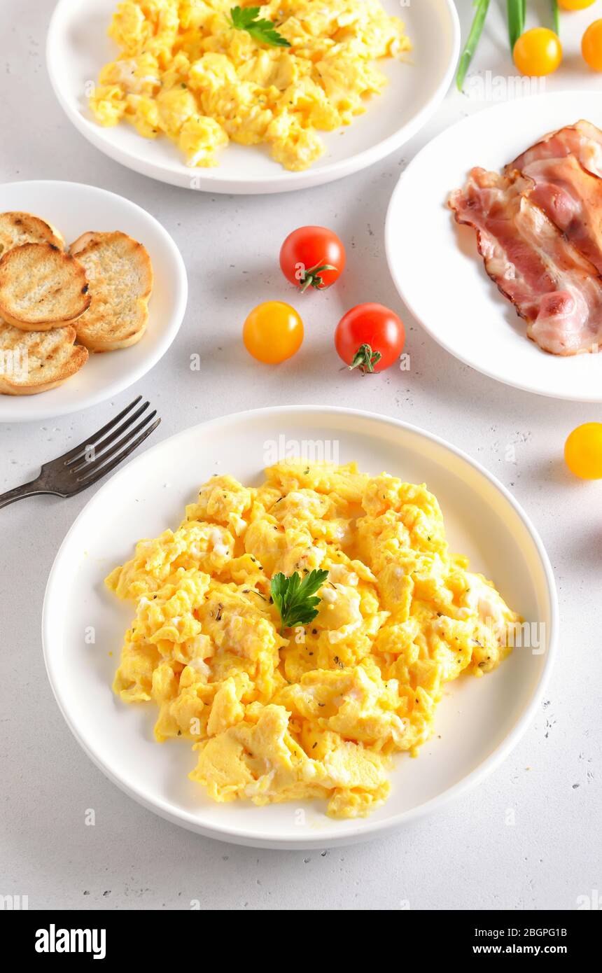 Plate with scrambled egg and bacon on white background Stock Photo - Alamy