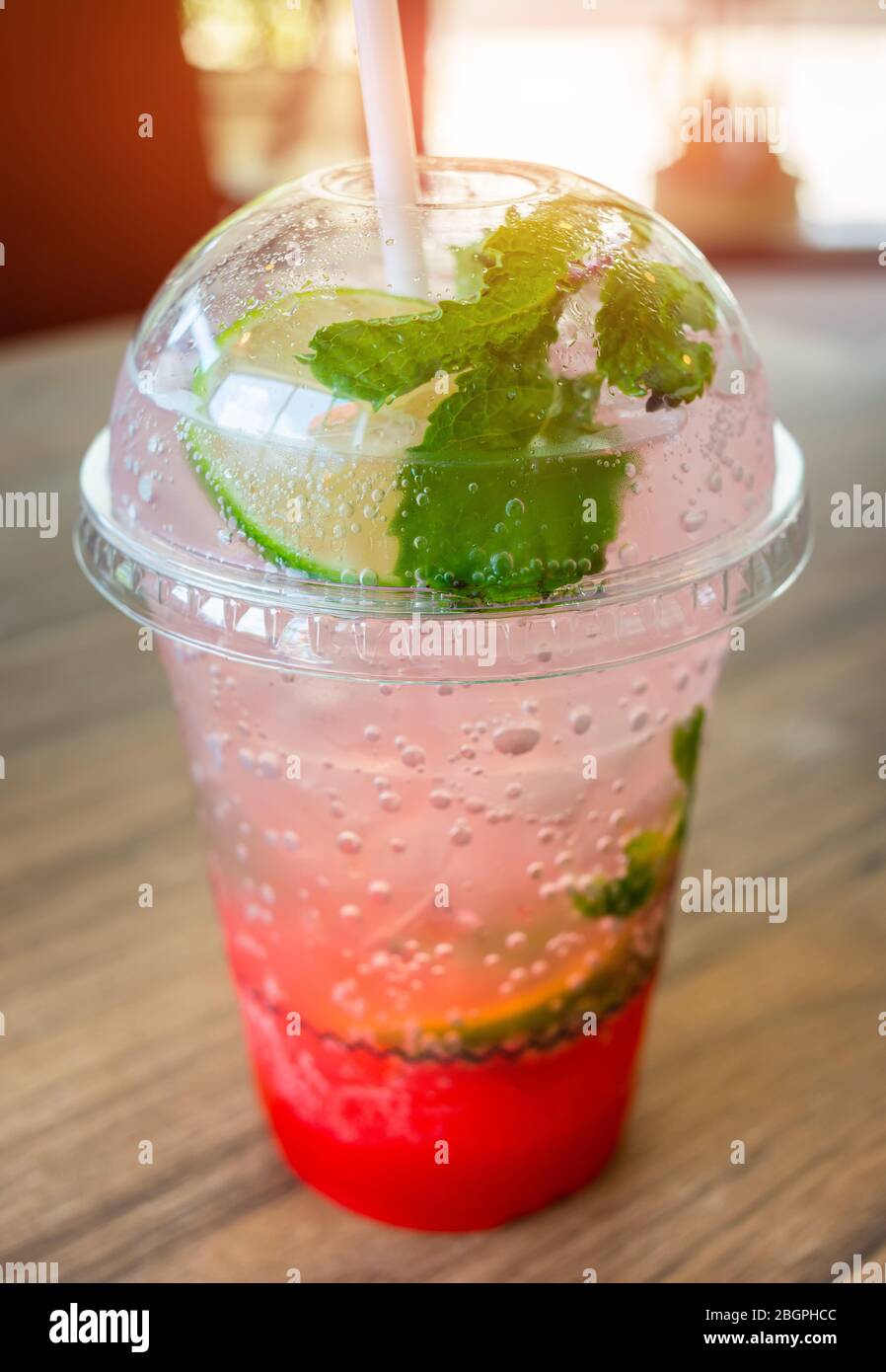 Ice soda sweet drink in plastic glass with in door low lighting. Stock Photo