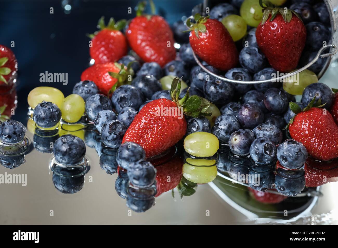 Fruit salad close up in falling metal bucket.Strawberry, grape ... Fruit salad close up in falling metal bucket.Strawberry, grape ...