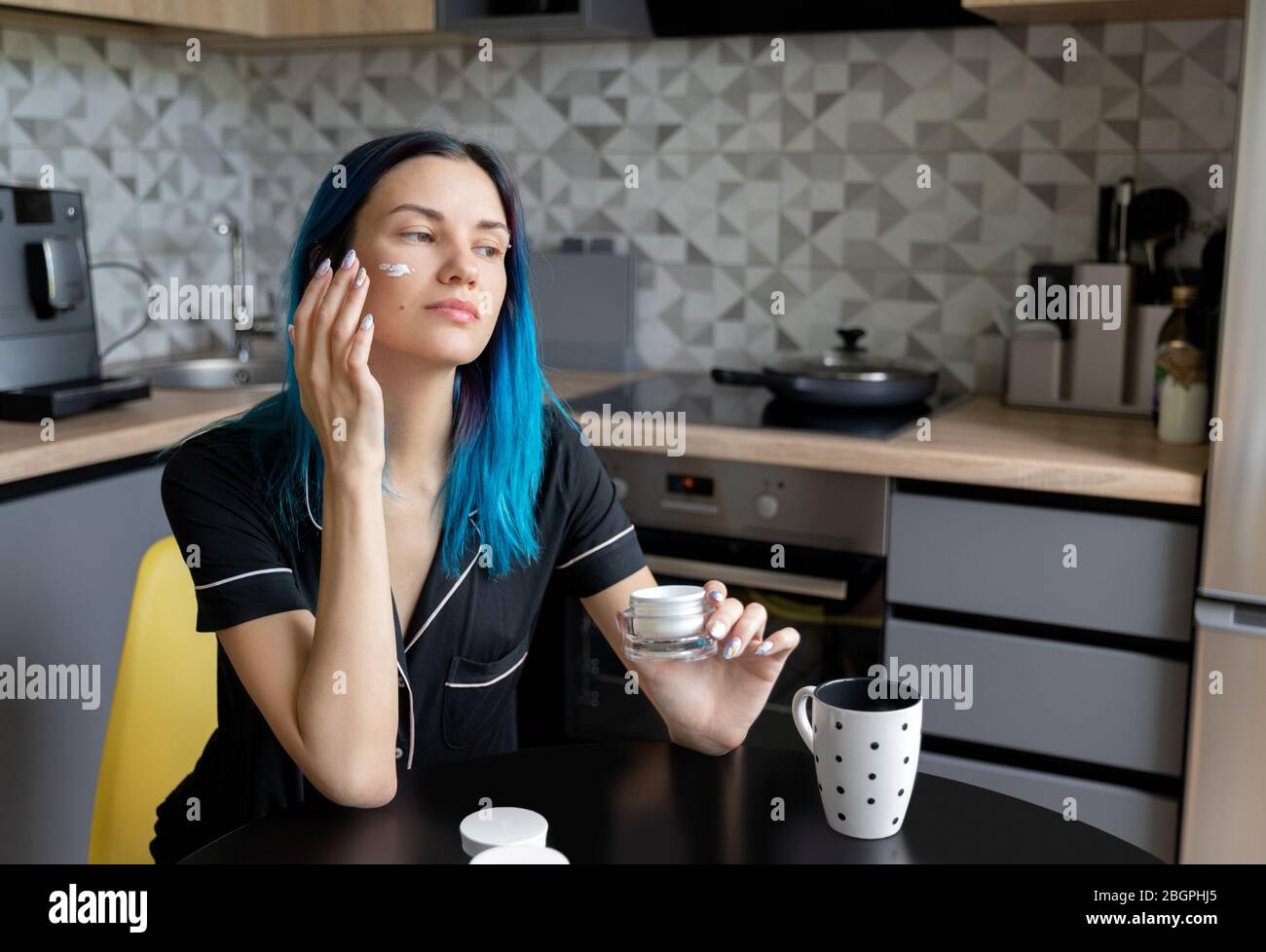 Beautiful Young Hipster Woman Applying Cream To Her Face At Modern Kitchen Stock Photo Alamy
