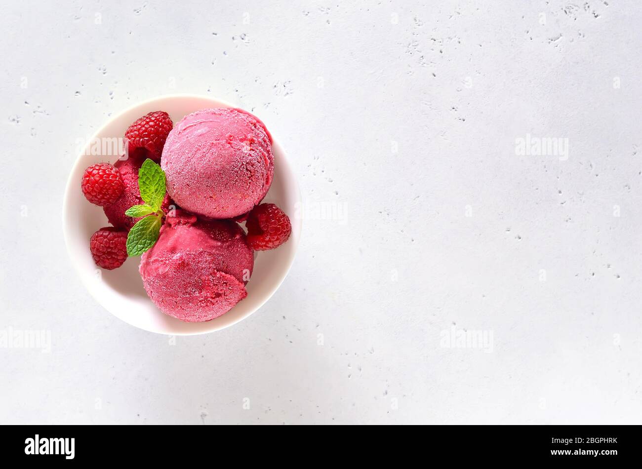 https://c8.alamy.com/comp/2BGPHRK/raspberry-ice-cream-scoop-with-fresh-raspberries-in-bowl-over-white-stone-background-with-free-text-space-top-view-flat-lay-2BGPHRK.jpg