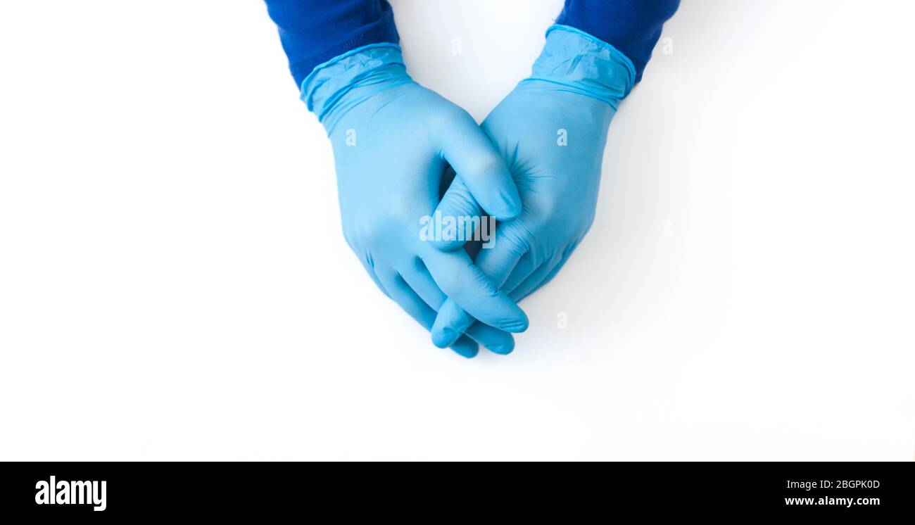 Blue Nitrile gloves banner. Hands of a medic in the blue latex gloves on white table Stock Photo