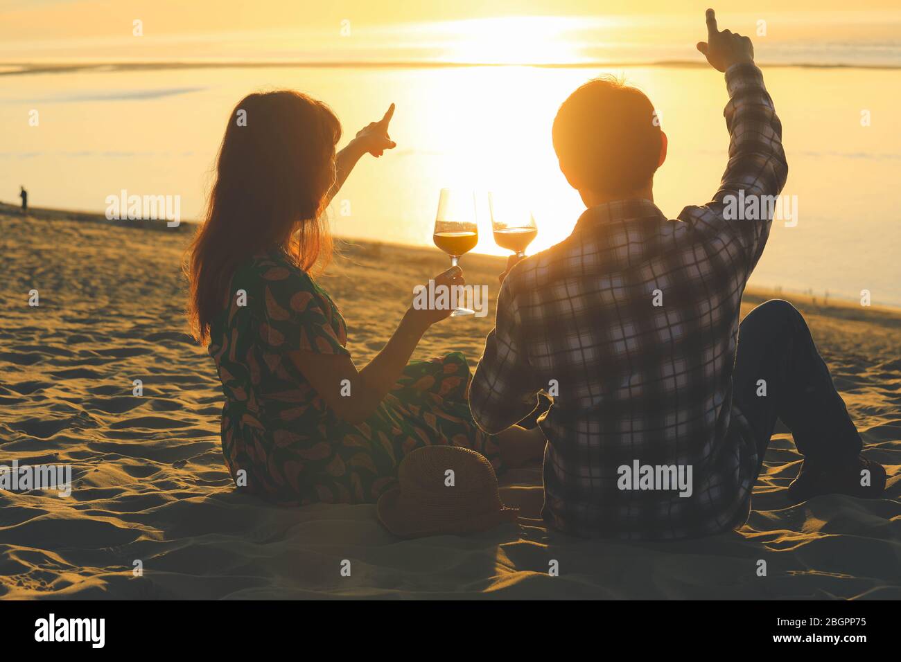 Couple celebration drinking red wine at sunset beach Stock Photo