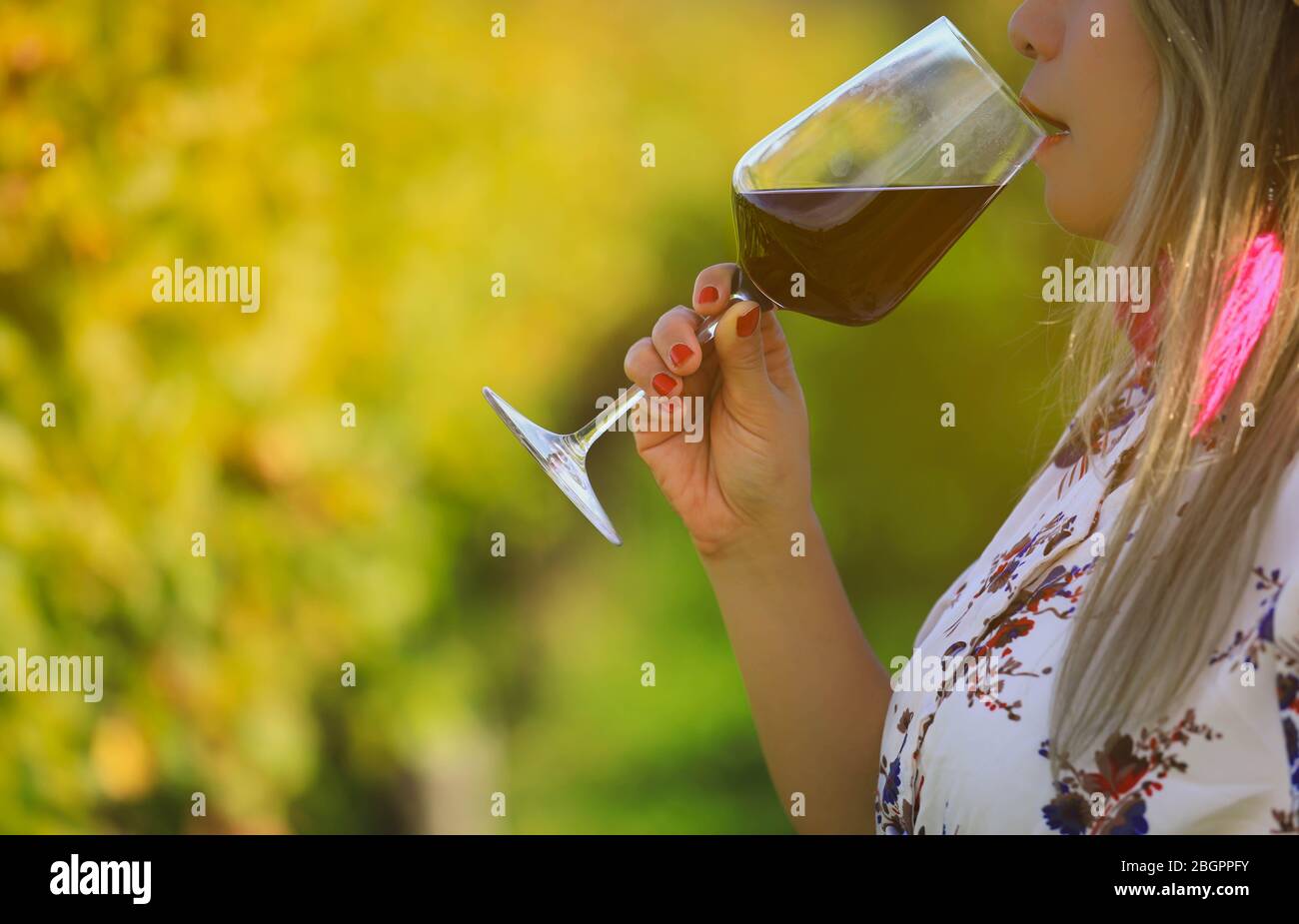 woman holding red wine glasse on the beach during sunset, celebration concept Stock Photo