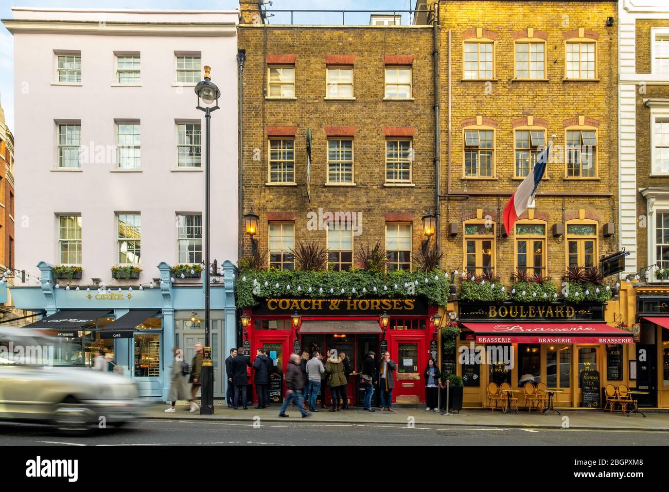 LONDON- FEBRUARY, 2020:  Typical West End street scene with motion blurred traffic and pubs and restaurants set in attractive Georgian architecture Stock Photo