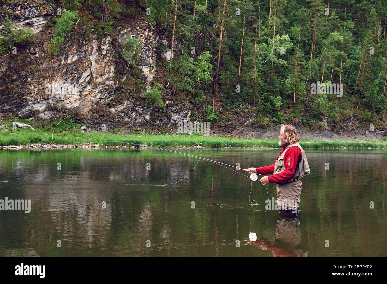 fly fishing angler makes cast while standing in water Stock Photo Alamy