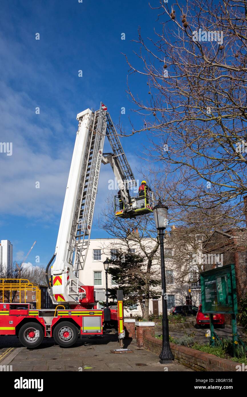 Firefighters in a tall crane rescuing a person from a height using a