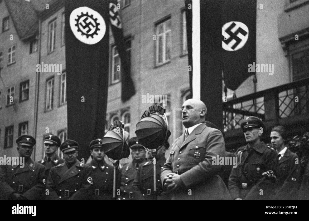 Gauleiter Julius Streicher (1885-1946), delivering a speech at the 'opening of the Third Craft Competitions of the Province of Franconia on the Adolf Hitler Square, Nurnberg, February 2, 1936, German Worker's Front, Franconia.'  Streicher was addressing ranks of uniformed men and boys. Note the big round baffles covering and protecting the microphones from rain and wind.  Streicher was one of Hitler's earliest supporters and rewarded him with protection against whoever hated Streicher's anti-Jewish rantings and publications. To see my other WW II-related images, Search:  Prestor vintage WW II Stock Photo