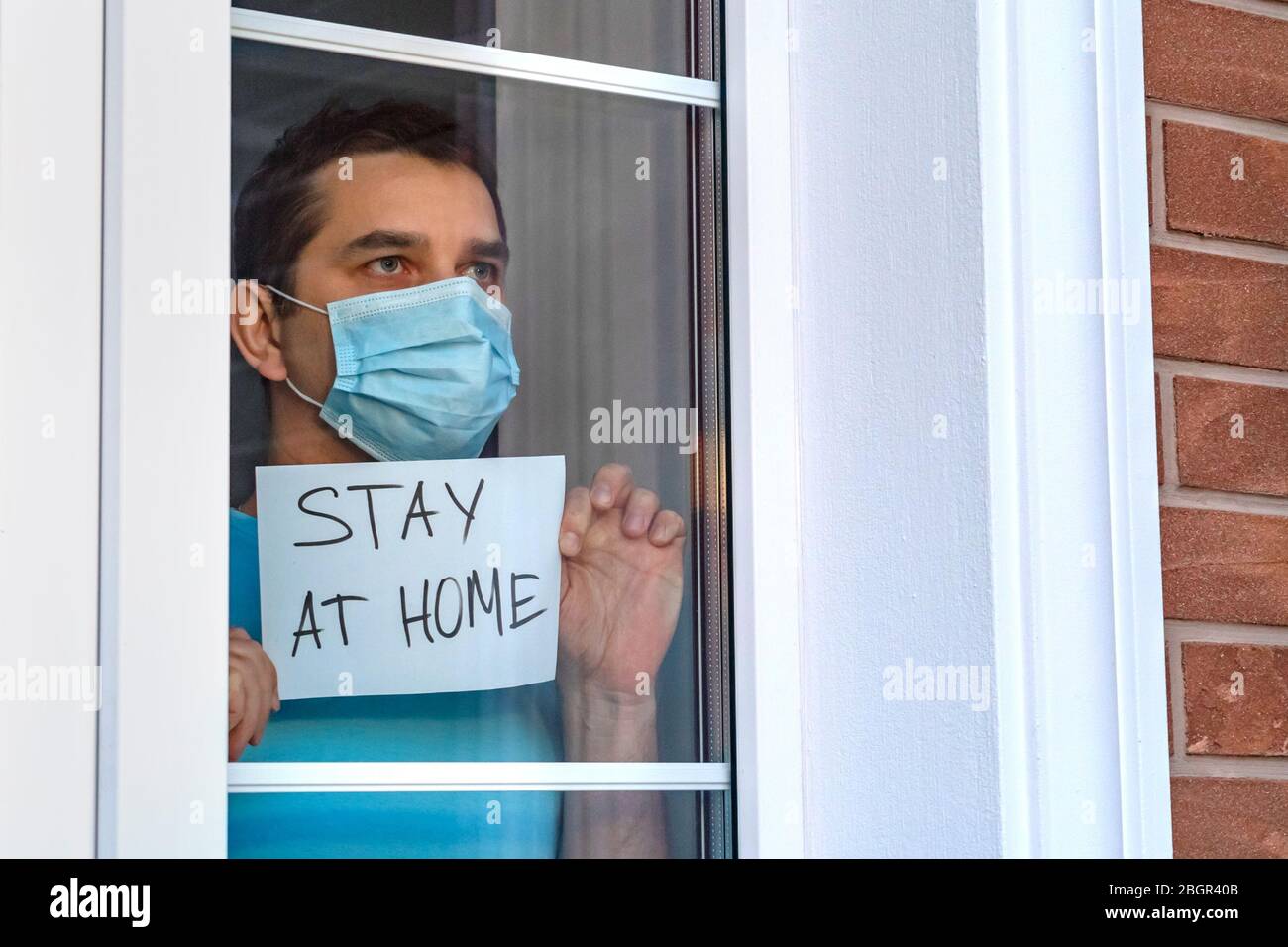 Man in medical mask stay at home. Self isolation. Stock Photo