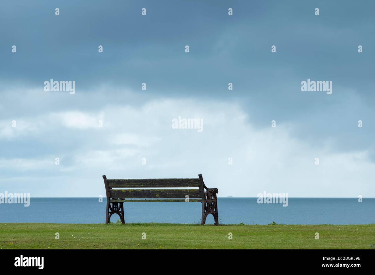 Empty bench seat and grey sky, Isle of Arran, Scotland Stock Photo