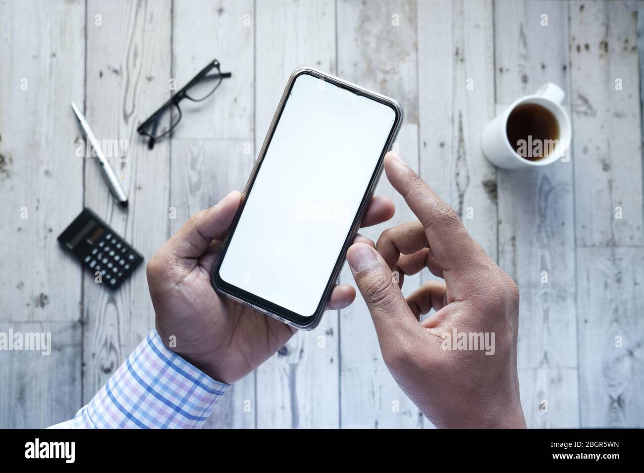 man holding smartphone with empty screen, high angle view  Stock Photo