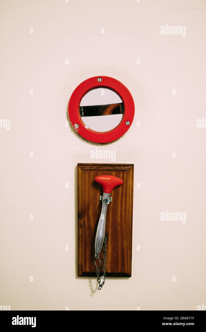 Hammer on the chain for breaking glass with fire alarm button Stock Photo -  Alamy