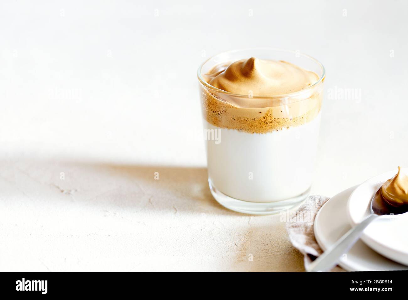 Trendy fluffy creamy whipped iced Dalgona coffee on white background.Korean drink latte espresso with foam of instant coffee.Horizontal orientation Stock Photo