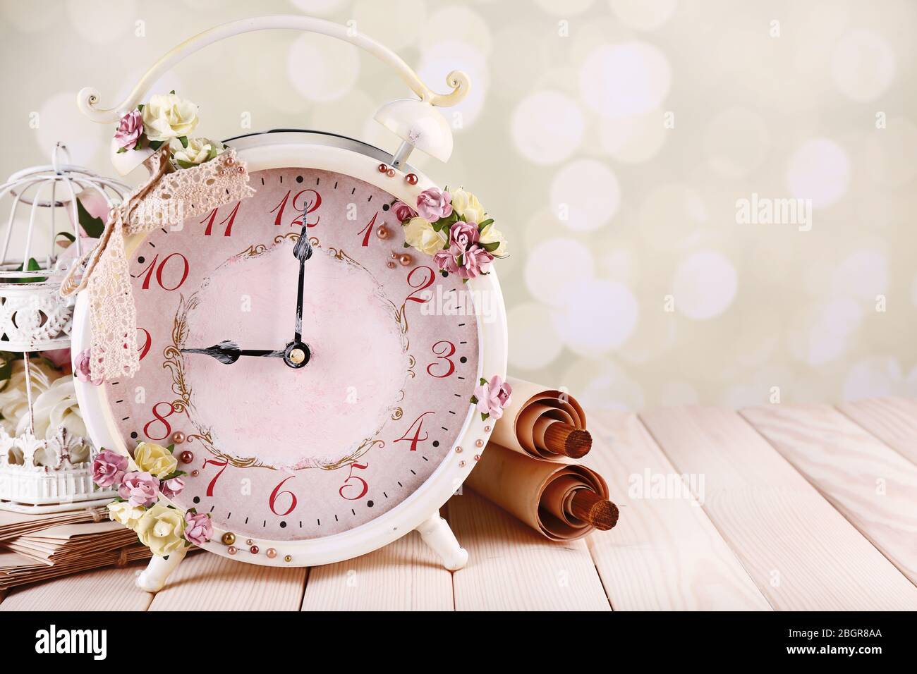 Beautiful vintage alarm clock with flowers on light background Stock ...