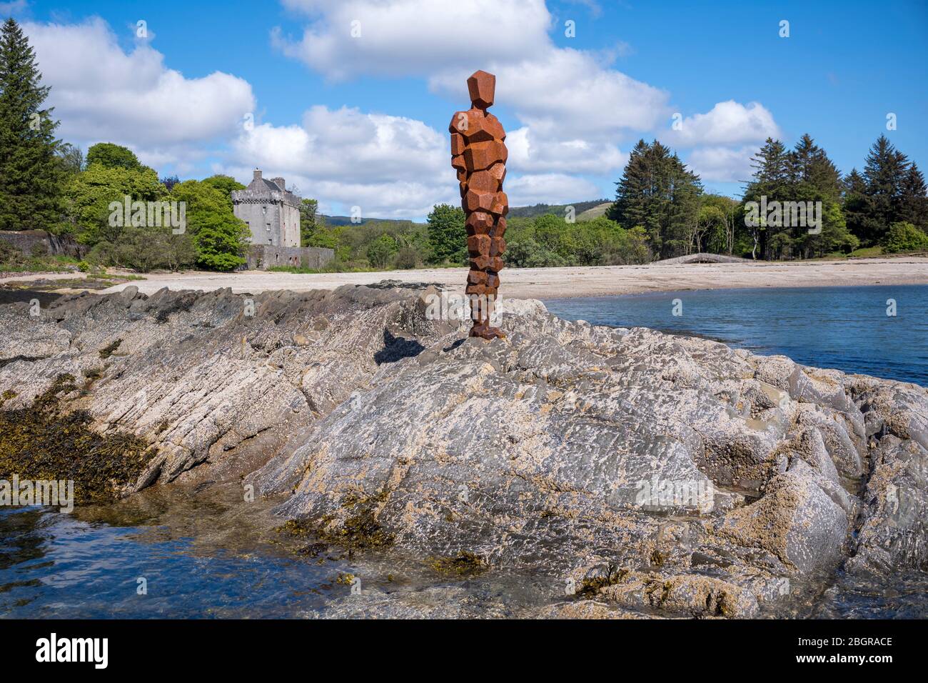 Antony Gormley sculpture GRIP of an abstract human form looking out over Saddell Bay, Kilbrannan Sound to Arran, Saddell Castle in background in Kinty Stock Photo