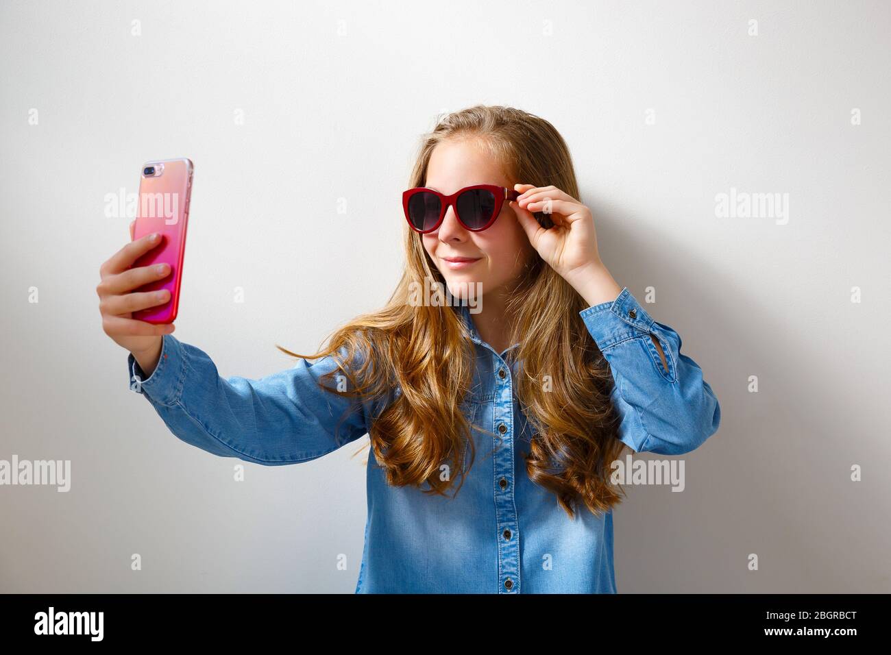 Teenager girl over purple wall making a selfie Stock Photo