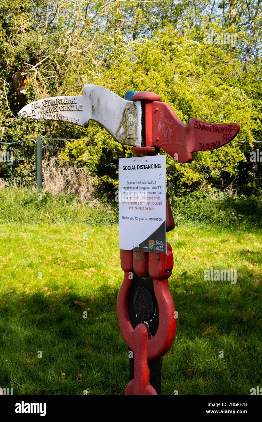Social distancing notice on a route marker, Queen Elizabeth Park. Corona Virus, Covid-19. Grantham, Lincolnshire, England. April 2020 Stock Photo