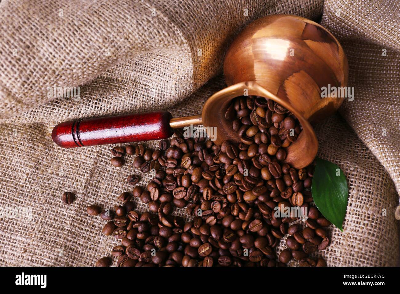 Coffee beans in ibrik on sacking background closeup Stock Photo