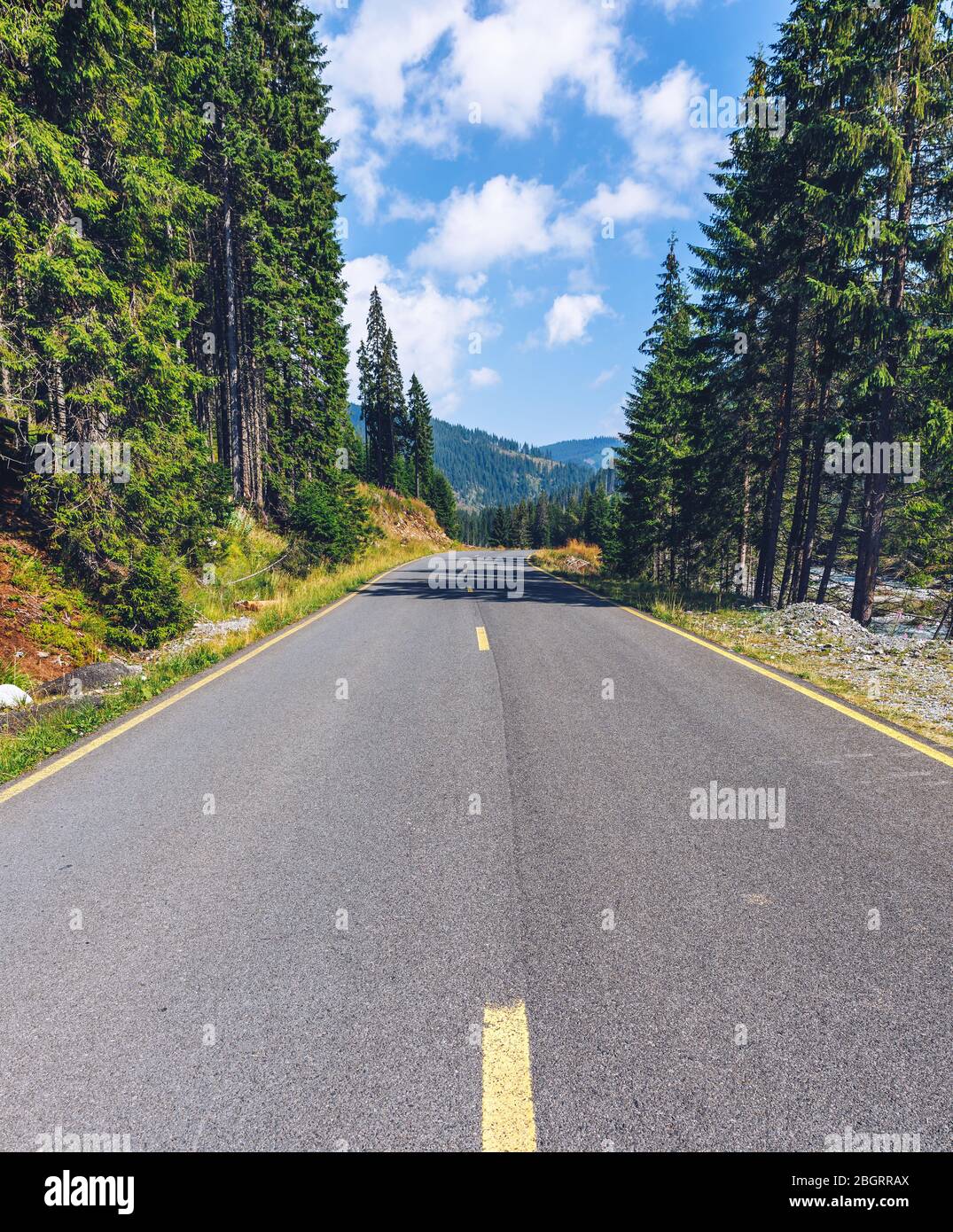 Mountain road. Landscape with rocks, sunny sky with clouds and beautiful asphalt road in the evening in summer. Vintage toning. Travel background. Hig Stock Photo