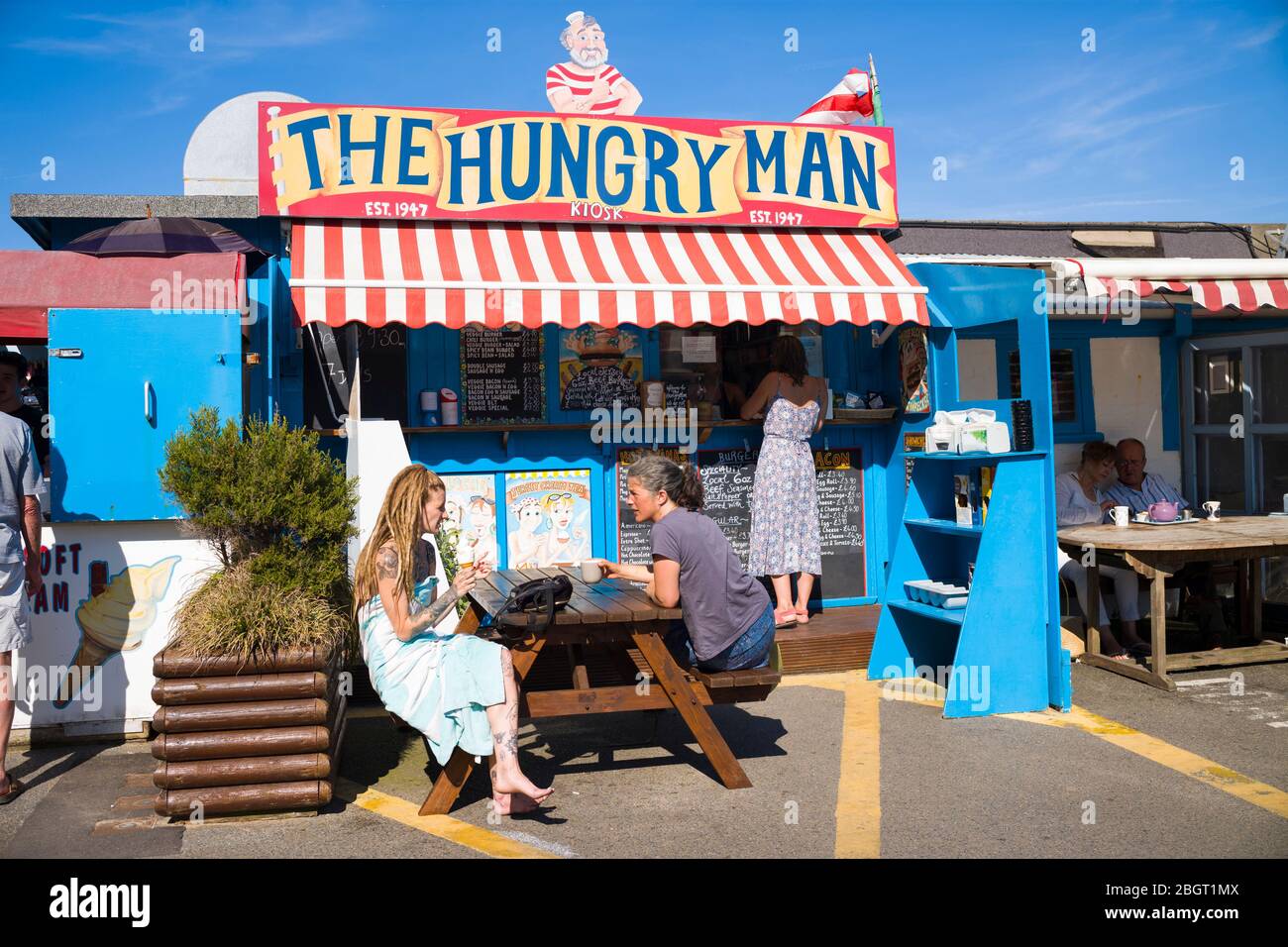 Holidaymakers at The Hungry Man food stall in the harbour at Rozel in St Martin region of Jersey, Channel Isles Stock Photo