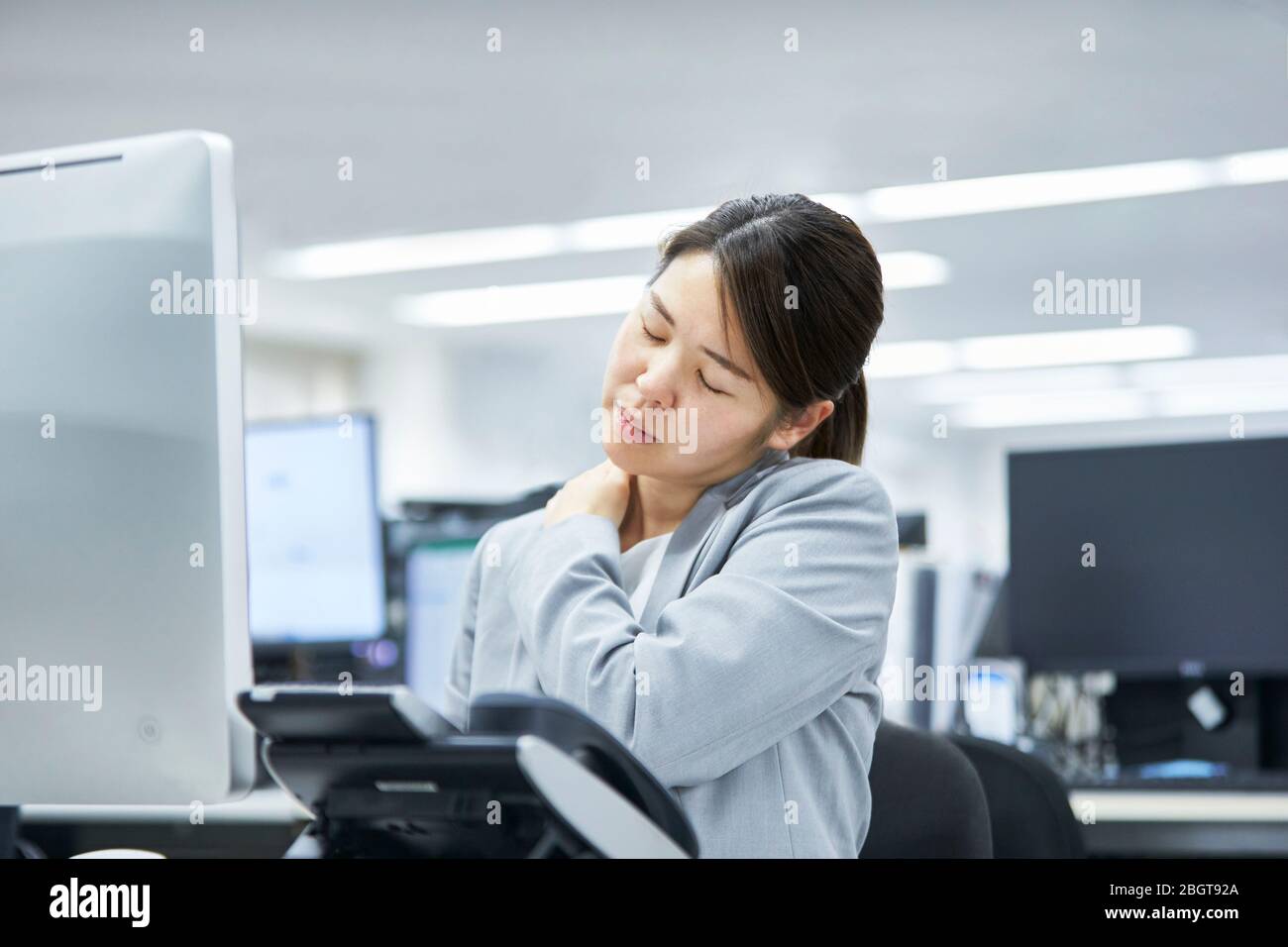 Tired Japanese businesswoman in the office Stock Photo