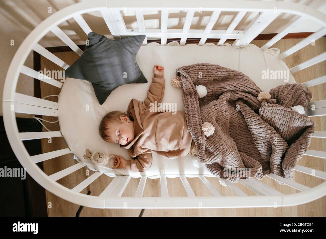 Cute little 1yearold baby is lying on a cot while sleeping with