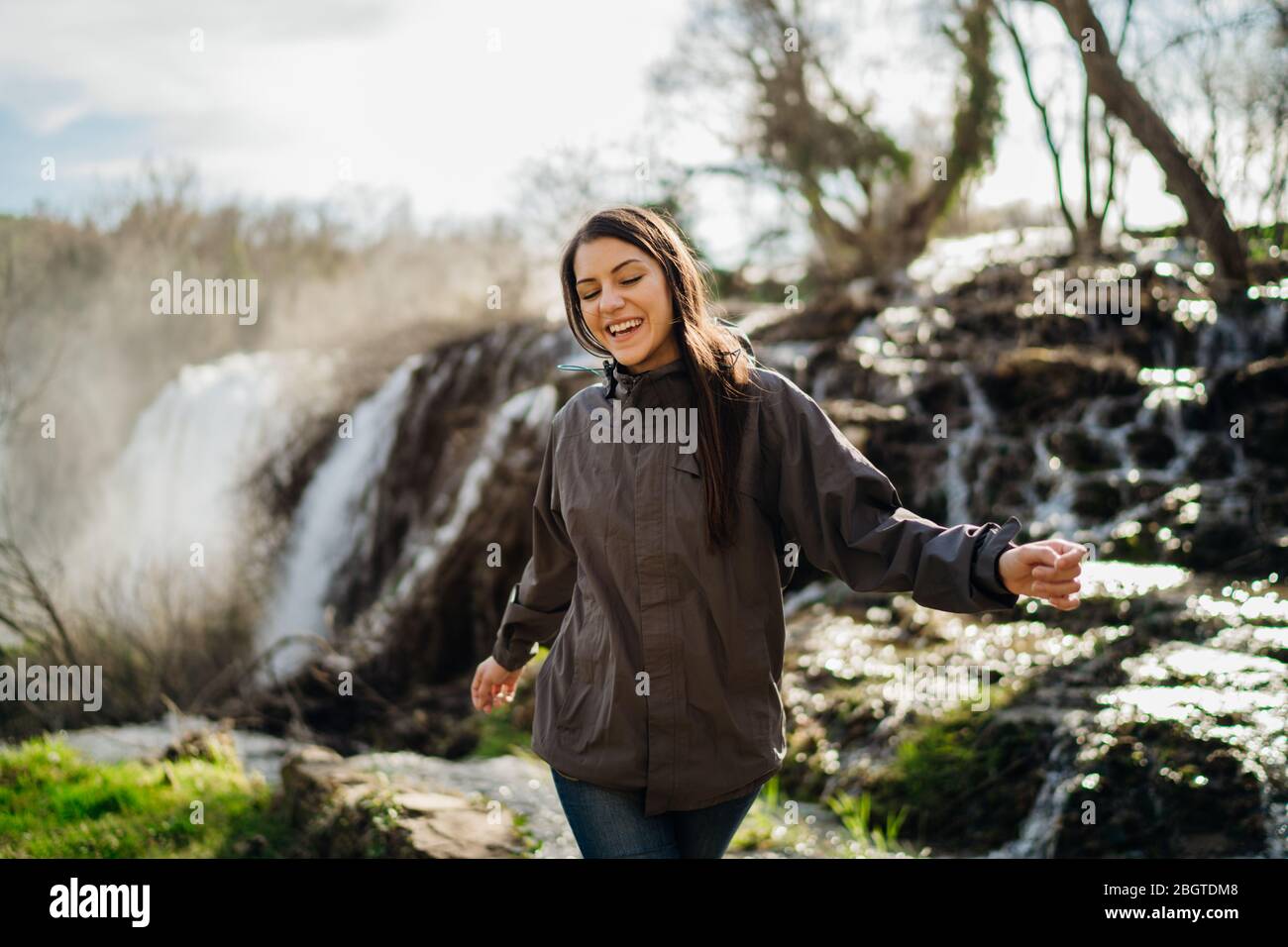 Woman tourist hiker visiting a mountain national park waterfall trail.Adventure tourist exploring nature.Nature and environment lover.Healthy lifestyl Stock Photo