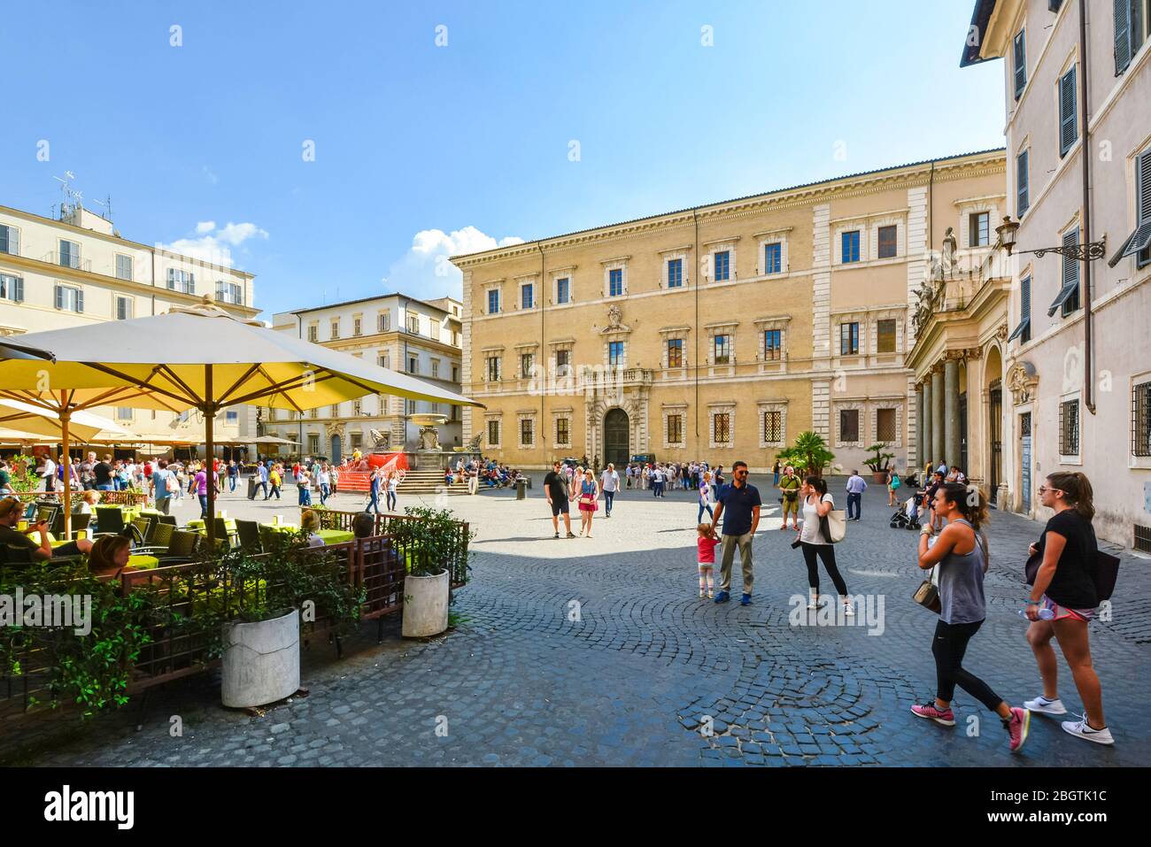 Lively summer day at the Piazza Santa Maria in Trastevere in Rome Italy as tourists and locals enjoy the cafes and fountain outside the cathedral. Stock Photo