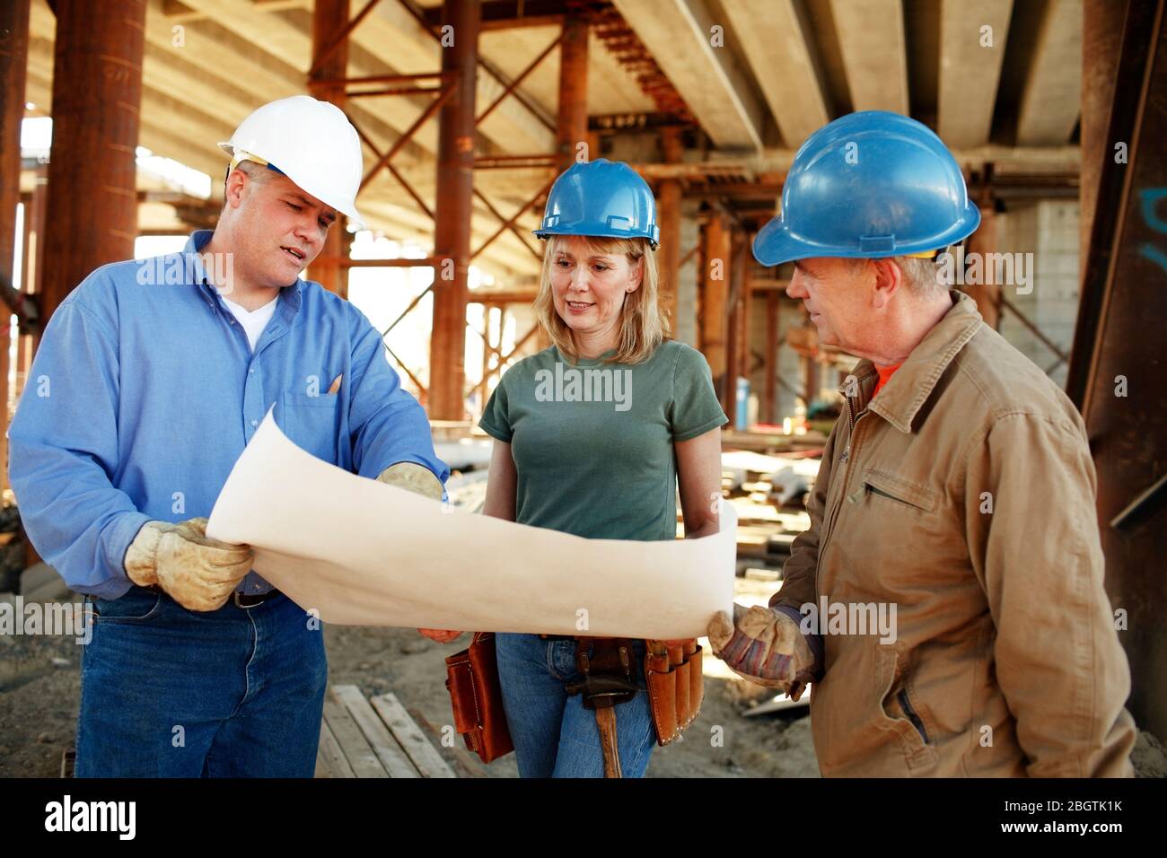 Group of construction workers looking over plans Stock Photo