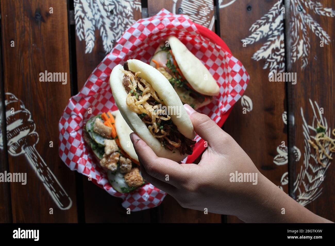 One Bao bun on hand with meat and vegetables Stock Photo