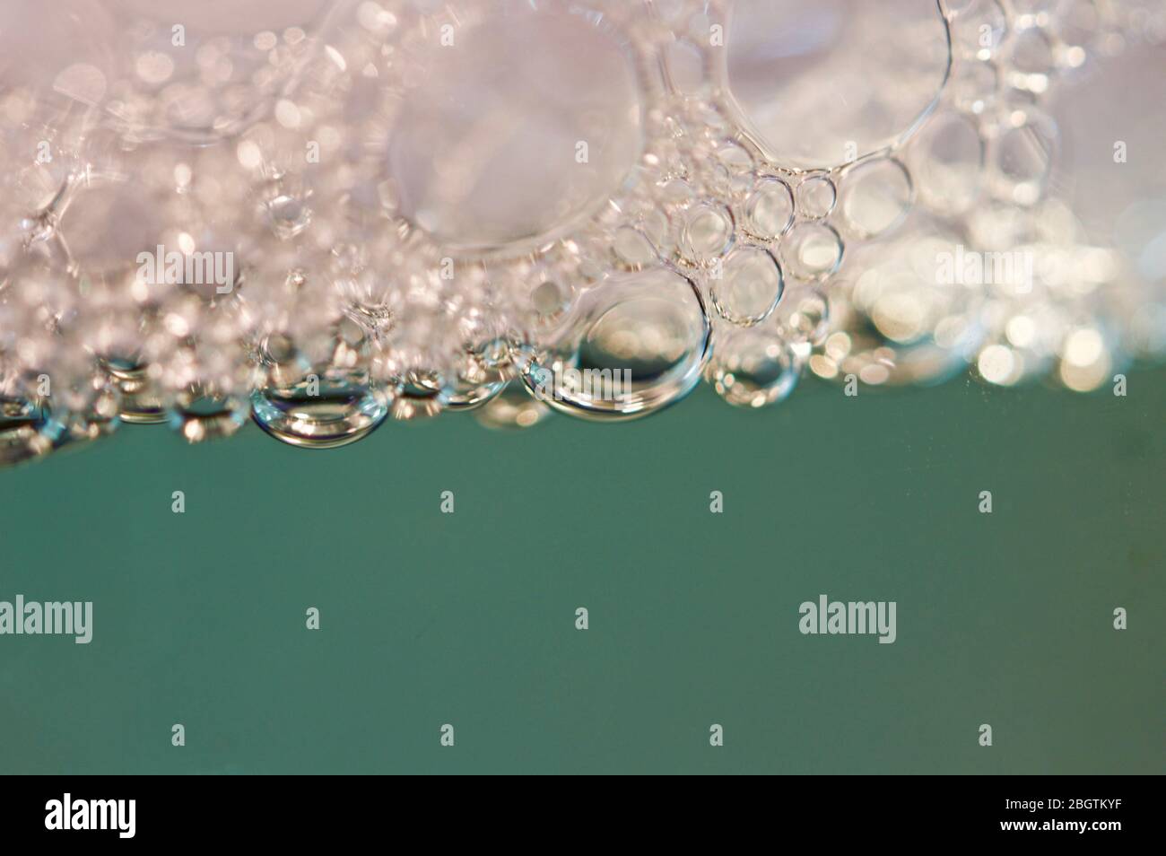 Red detergent bubbles in macro view Stock Photo