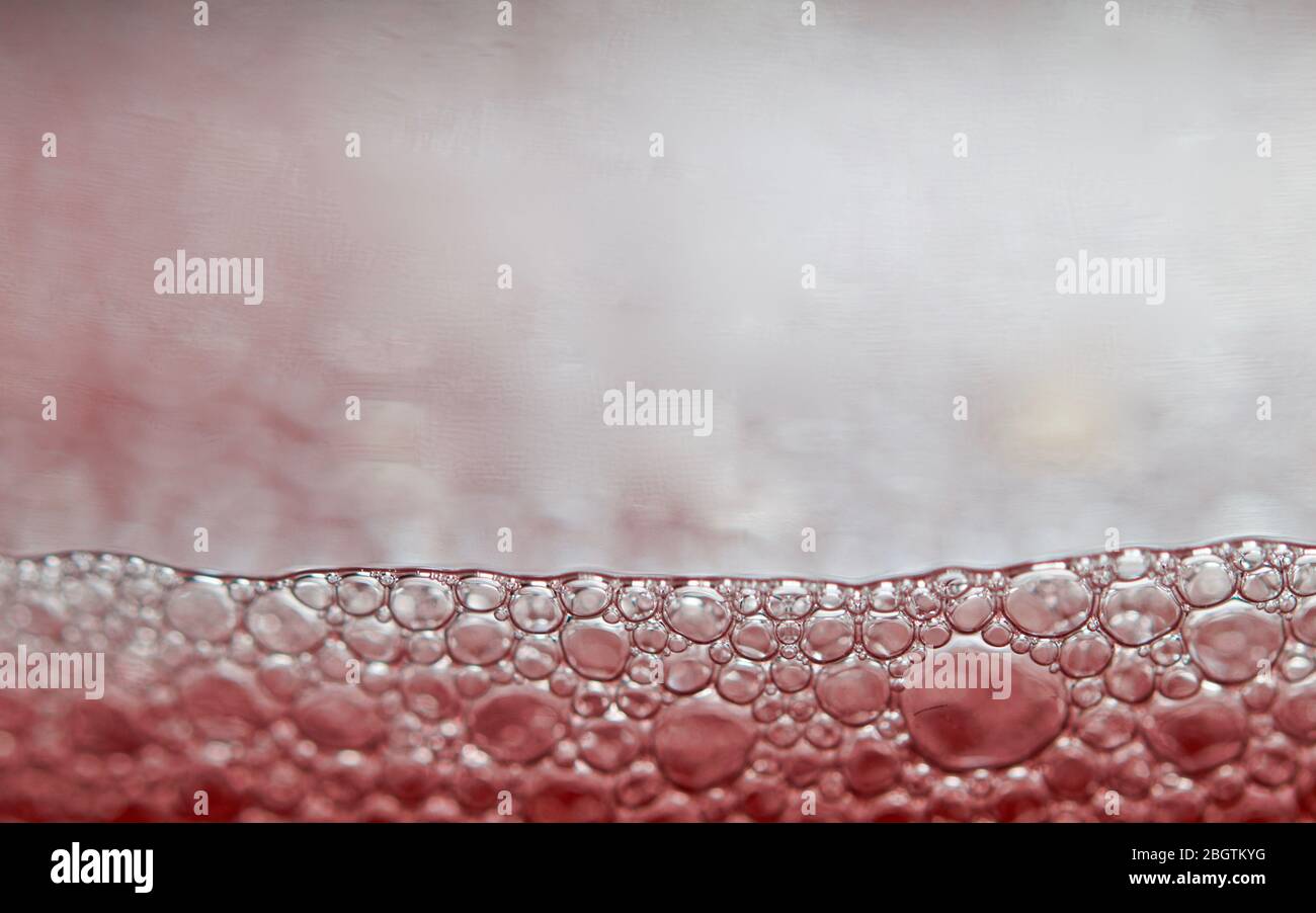 Red detergent bubbles in macro view Stock Photo