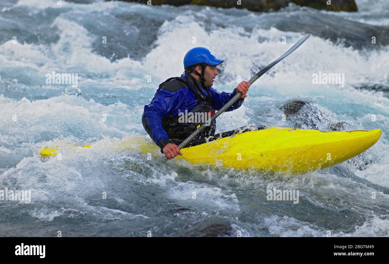 Man going on his white water kayak  rapids in an Icelandic river Stock Photo