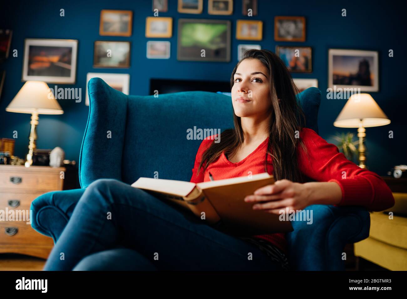 Woman enjoying reading an interesting book novel,home alone in quarantine.Mental health self care,relaxing home activity.Improving yourself,education Stock Photo