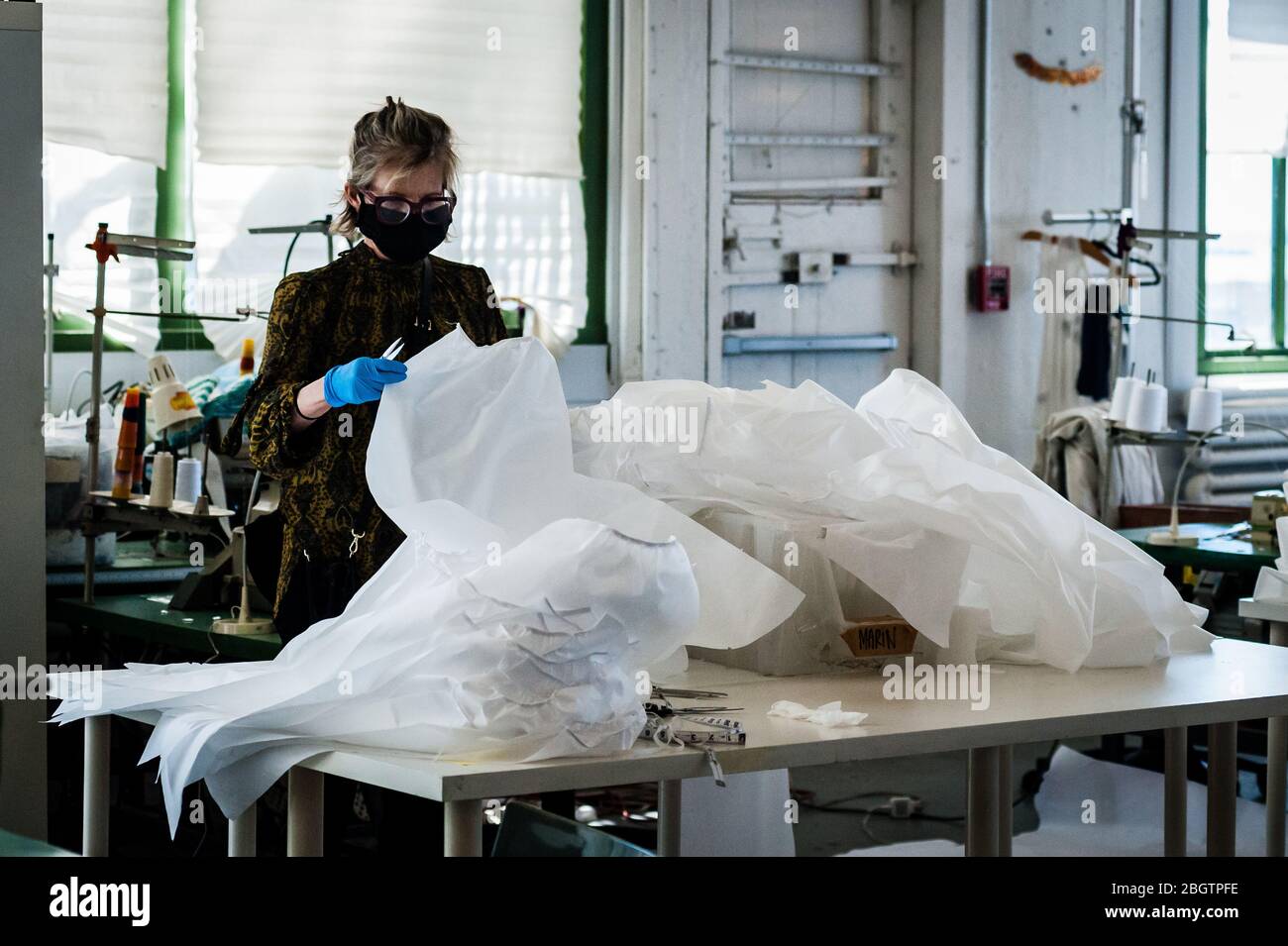 Brooklyn, United States Of America . 22nd Apr, 2020. A seamstress prepares the fabric for reusable hospital gowns for frontline healthcare workers at Malia Mills, a fashion garment factory in Industry City in Brooklyn, New York, on April 22, 2020. (Photo by Gabriele Holtermann-Gorden/Sipa USA) Credit: Sipa USA/Alamy Live News Stock Photo