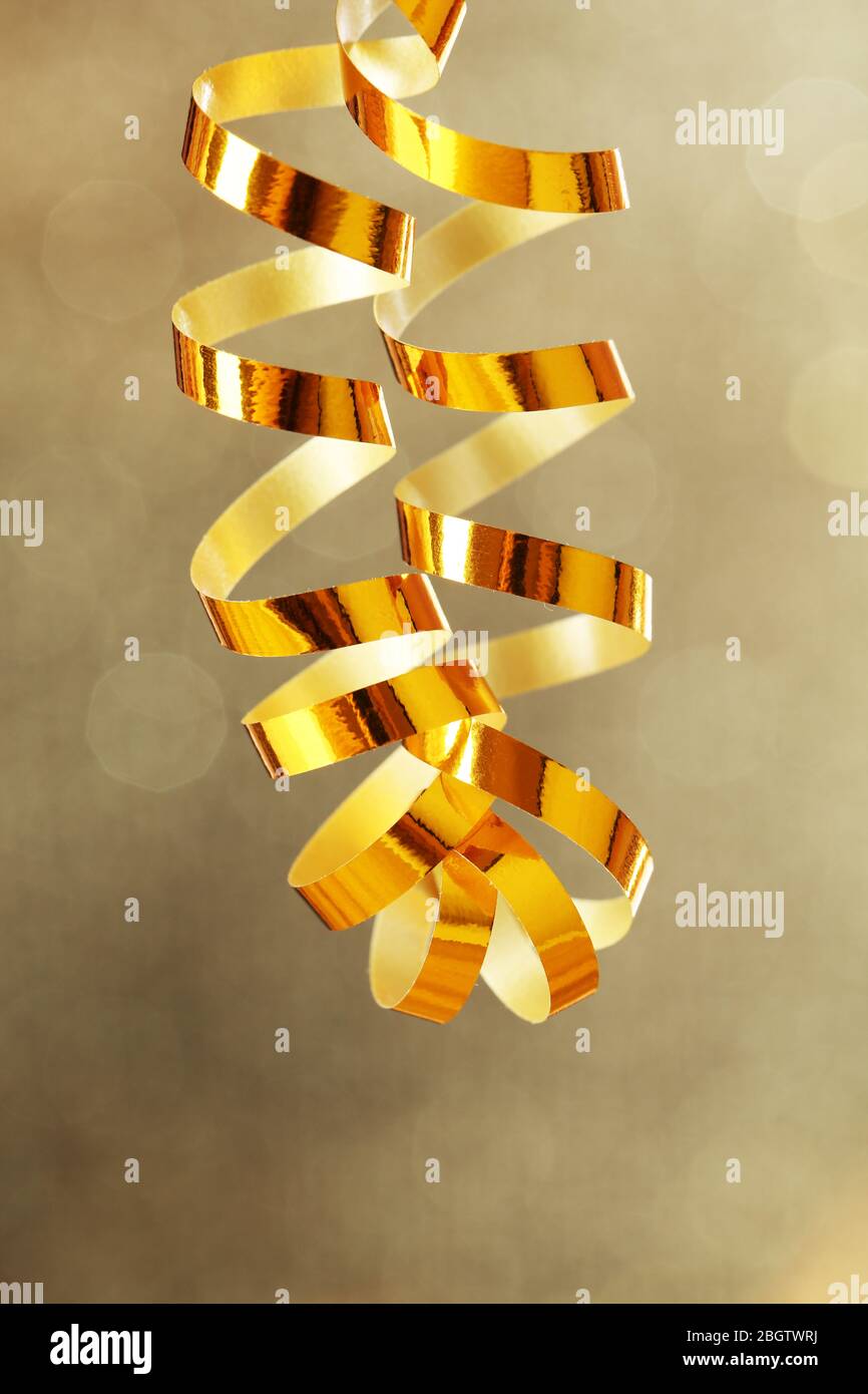 Serpentine ribbon on golden shiny background Stock Photo - Alamy