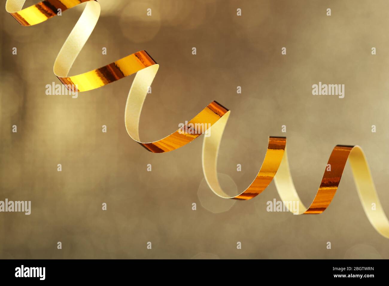 Serpentine ribbon on golden shiny background Stock Photo - Alamy
