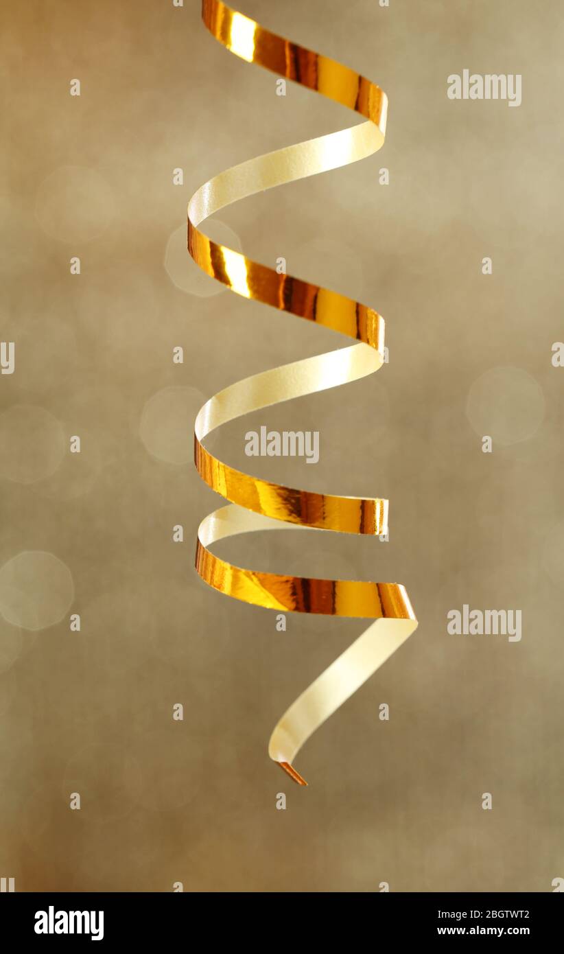 Serpentine ribbon on golden shiny background Stock Photo - Alamy