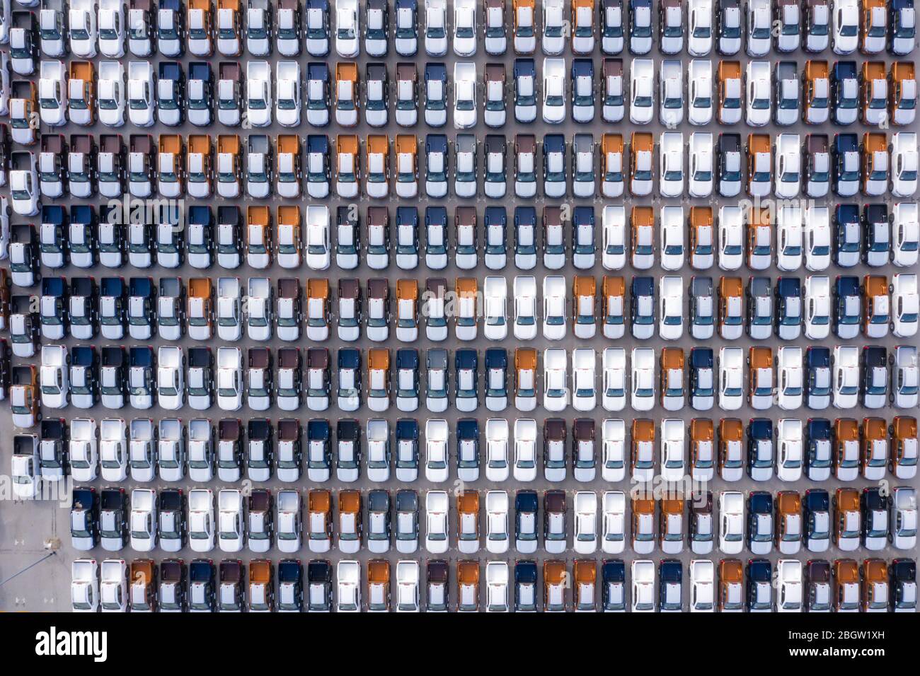 Aerial top view new cars lined up in the port for import export business logistic and transportation by ship in the open sea. New cars from the car fa Stock Photo