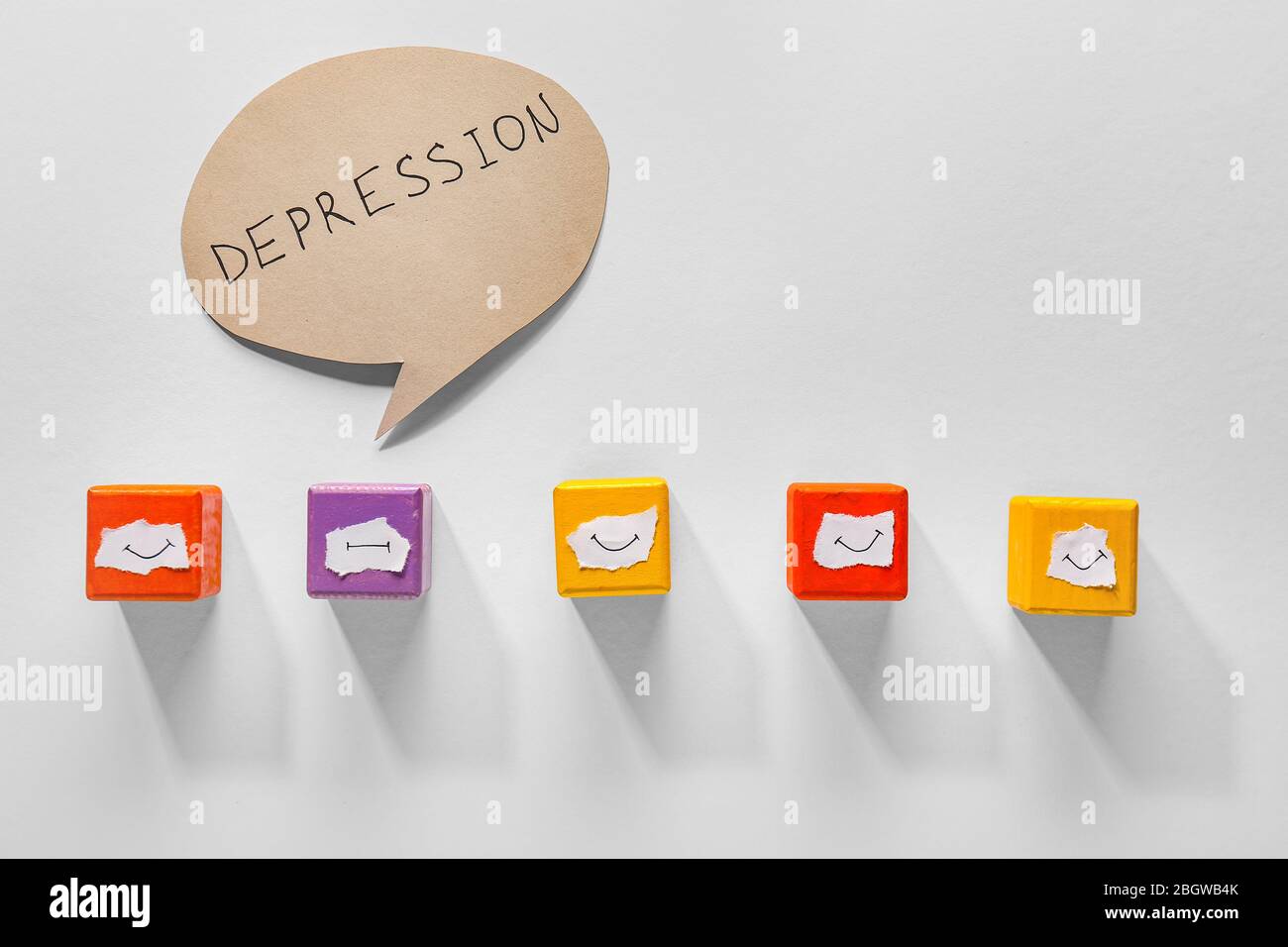 One cube with drawn neutral mouth among happy ones and speech bubble with text DEPRESSION on white background Stock Photo