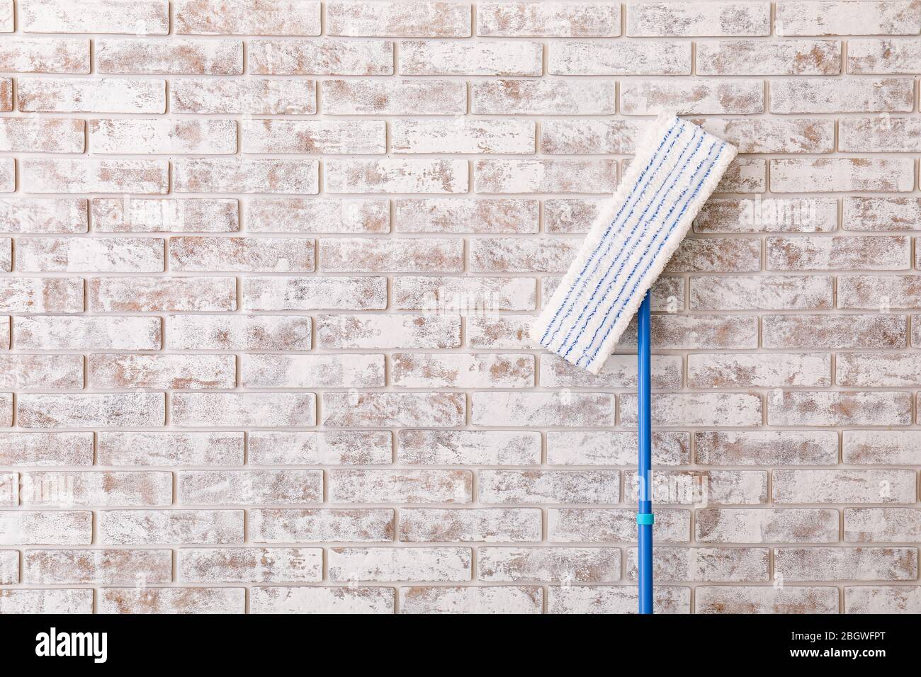 Floor mop on brick background Stock Photo - Alamy