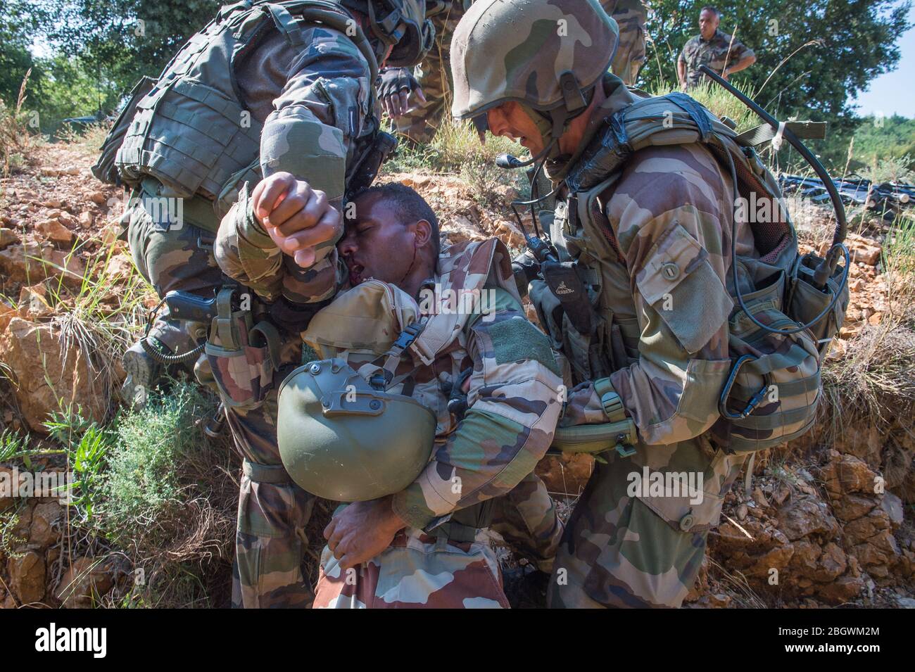 DRAGUIGNAN, FRANCE - JULY 21: Soldiers rescuing a fake wounded man during simulated conflict between soldiers and terrorists, with fake corpses, fake Stock Photo