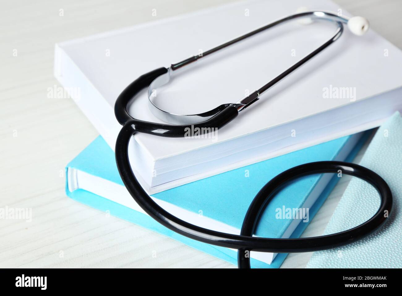 Medical stethoscope with books on wooden table Stock Photo - Alamy