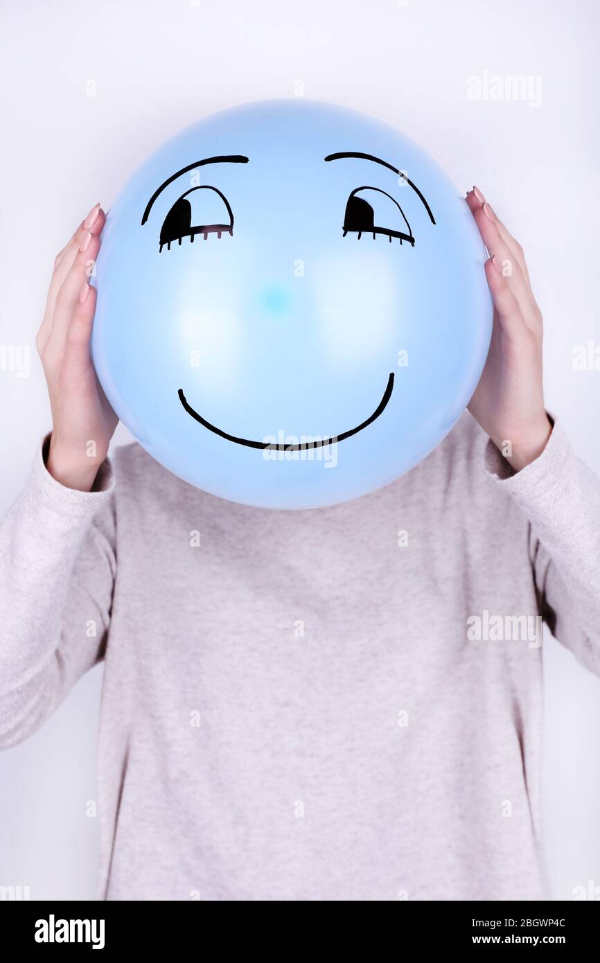Woman holding balloon in front of her face Stock Photo - Alamy